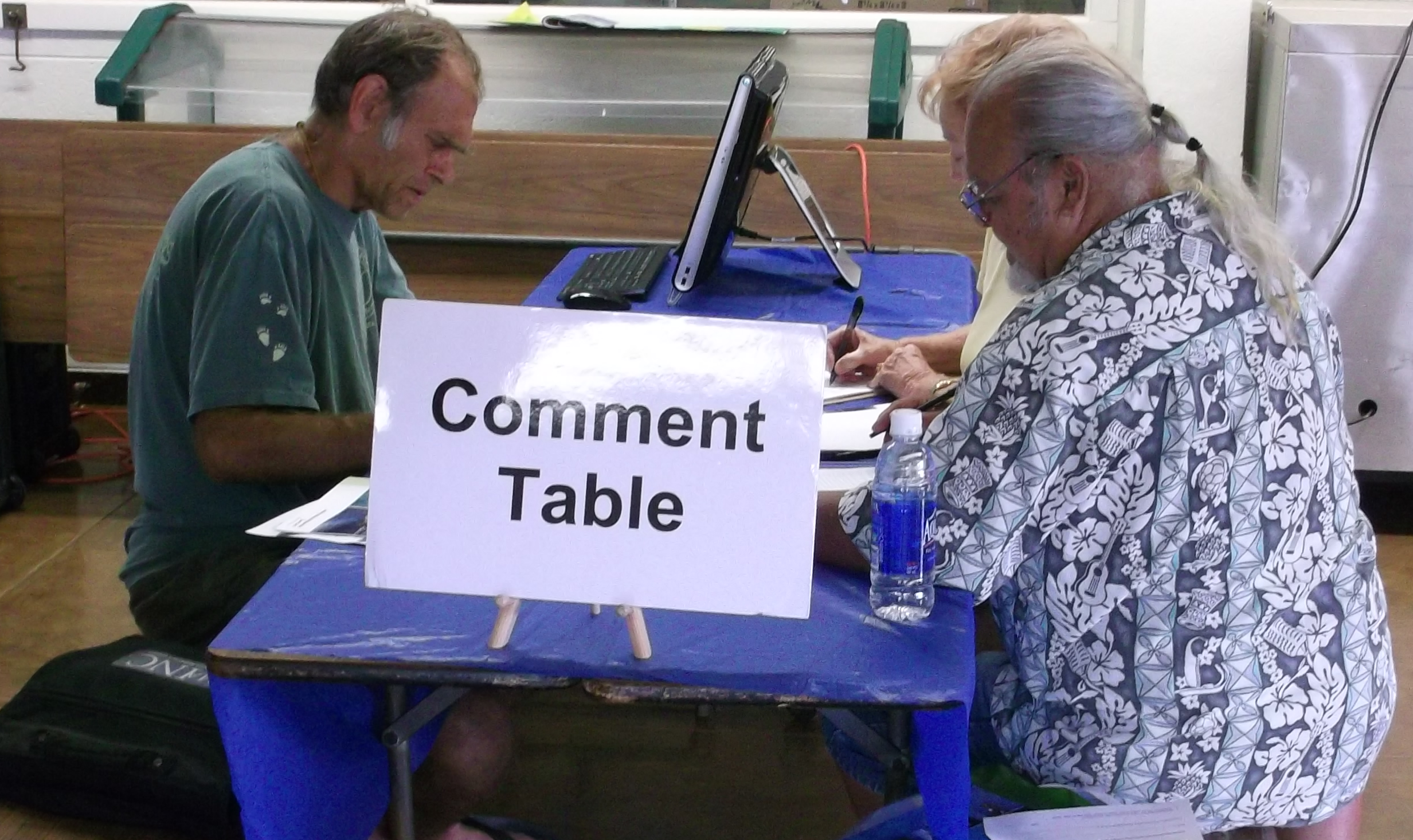 This is an image of a person writing a comment at a public meeting.